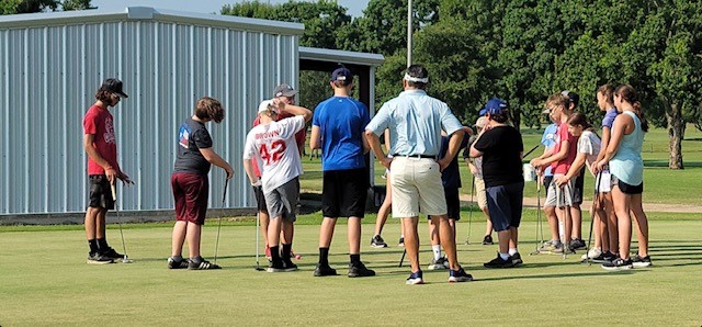 kids learning new with volunteer golf pro